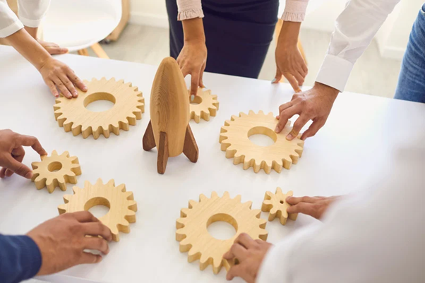 People holding cogwheels that represent strategies